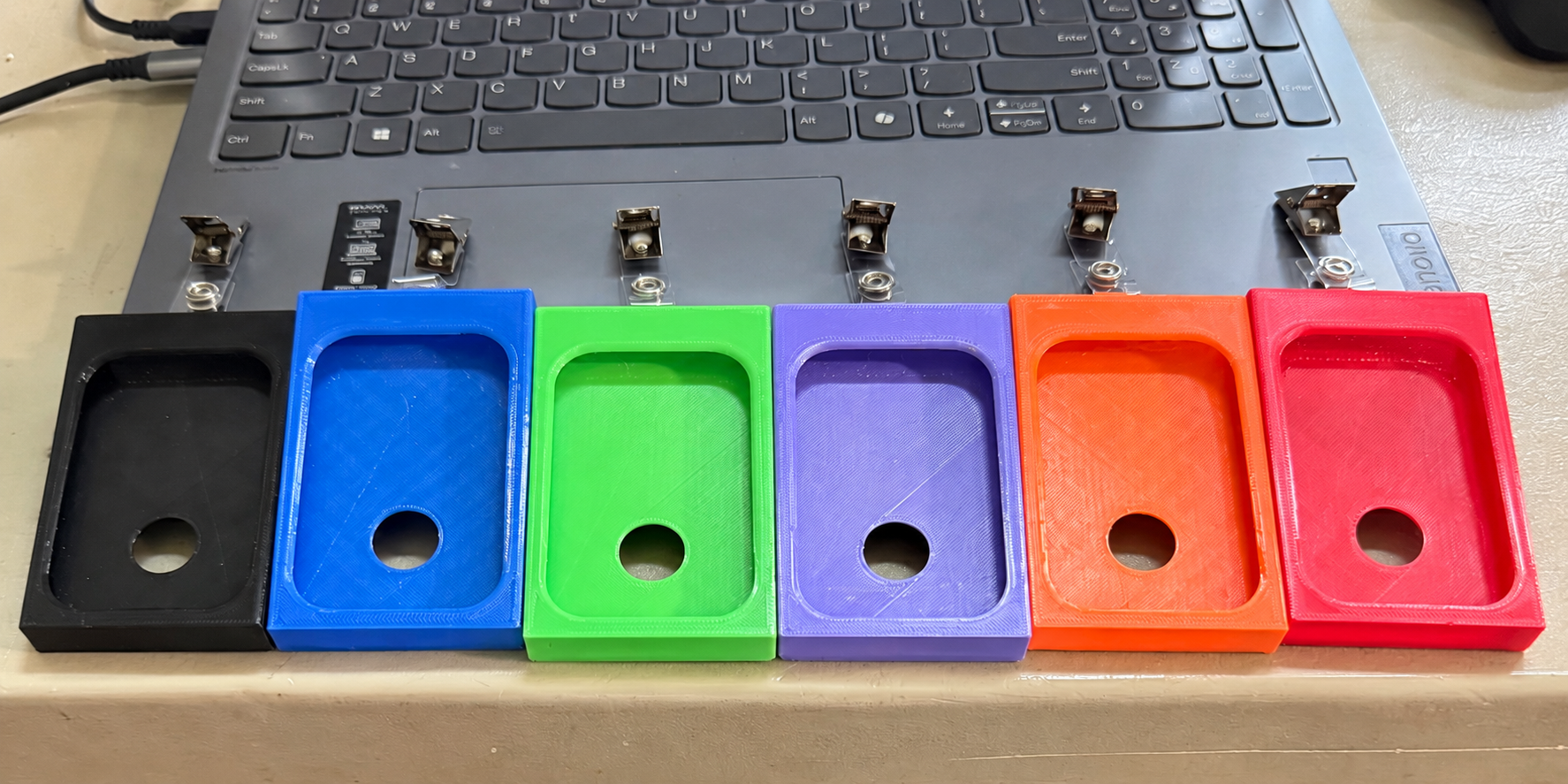 Six custom badge holders in black, blue, green, purple, orange, and red.